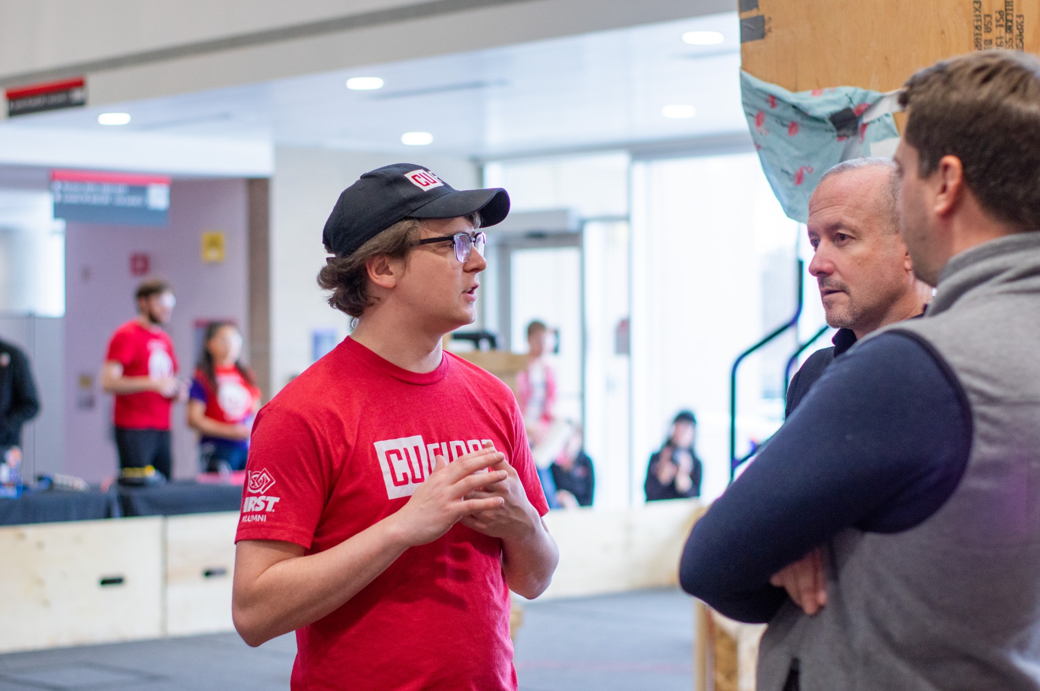 James Neumann speaking with guests during a CU FIRST robotics outreach event at Carleton University