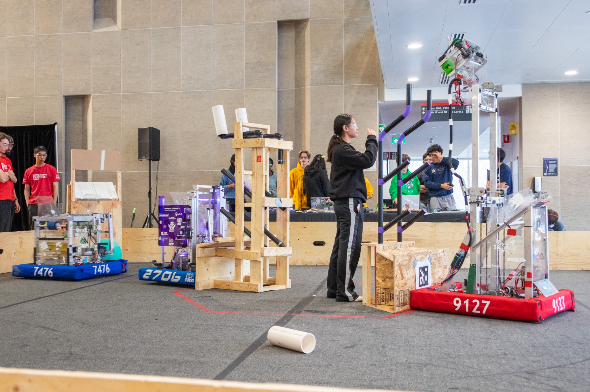 Student teams and robots operating on the CU FIRST practice field at Carleton University
