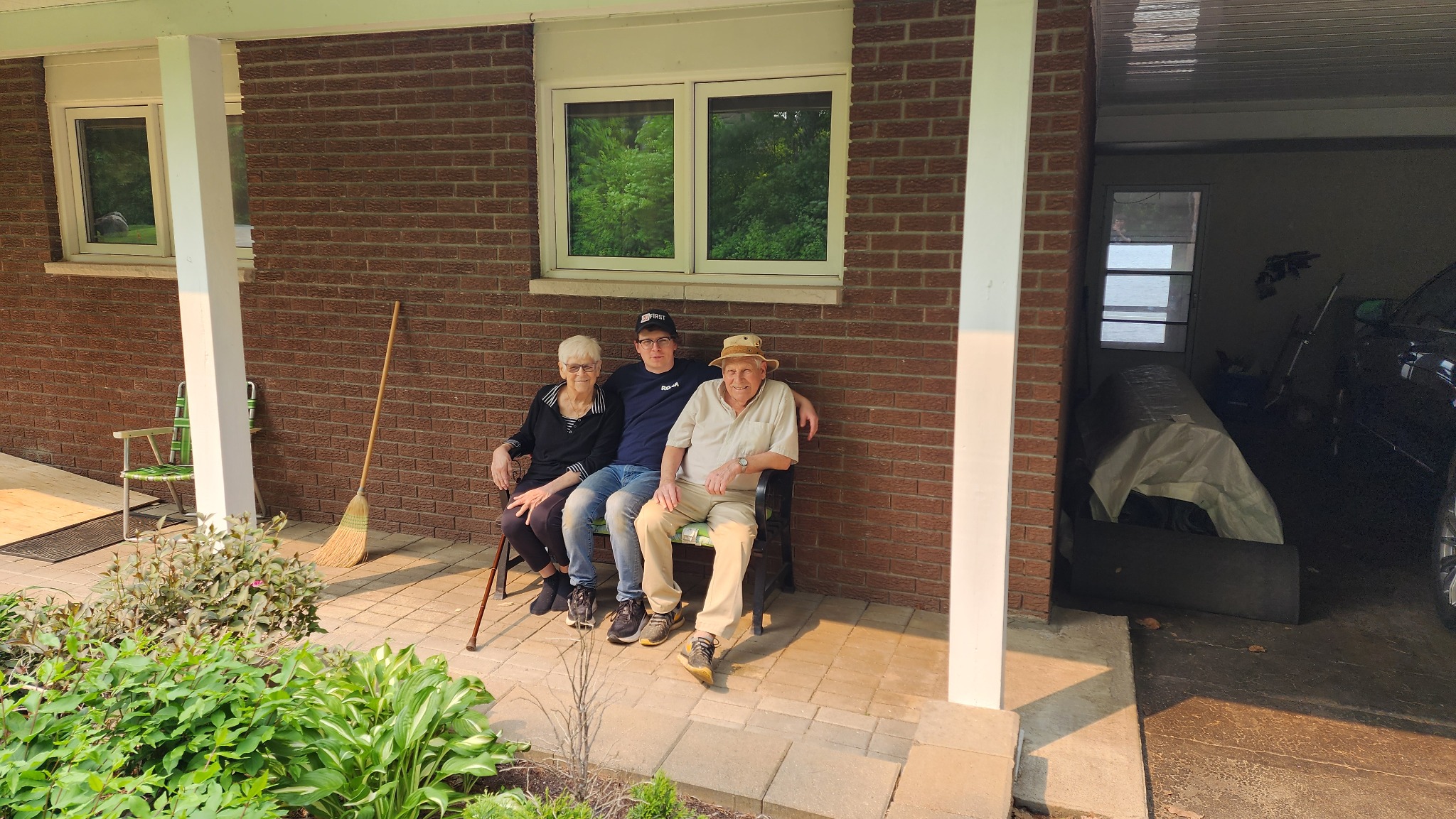 James Neumann seated outside with his grandparents